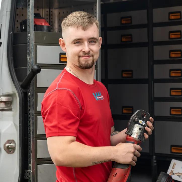 Albin på Växjö VVS vid servicebilen med pressverktyget i handen