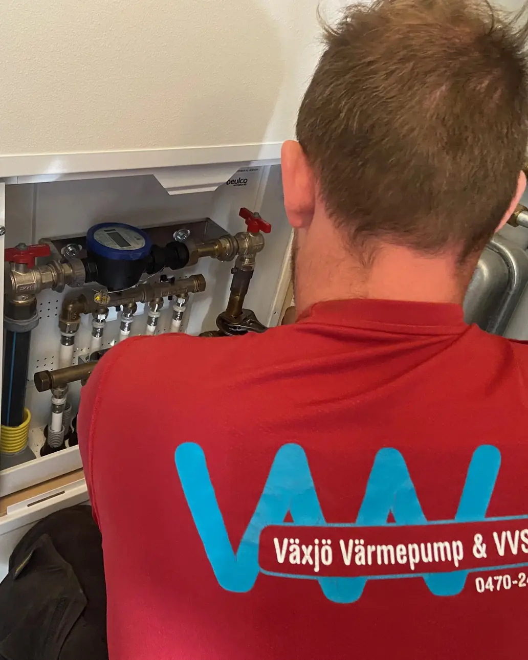 Rörmokare från Växjö VVS arbetar vid en fördelare med vattenmätare