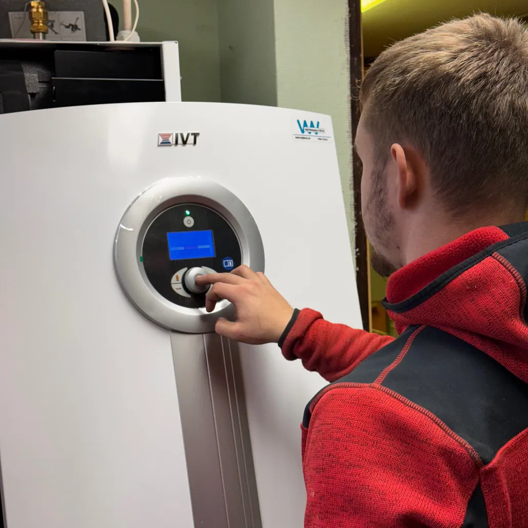 Servicetekniker från Växjö VVS läser av displayen på en IVT-bergvärmepump