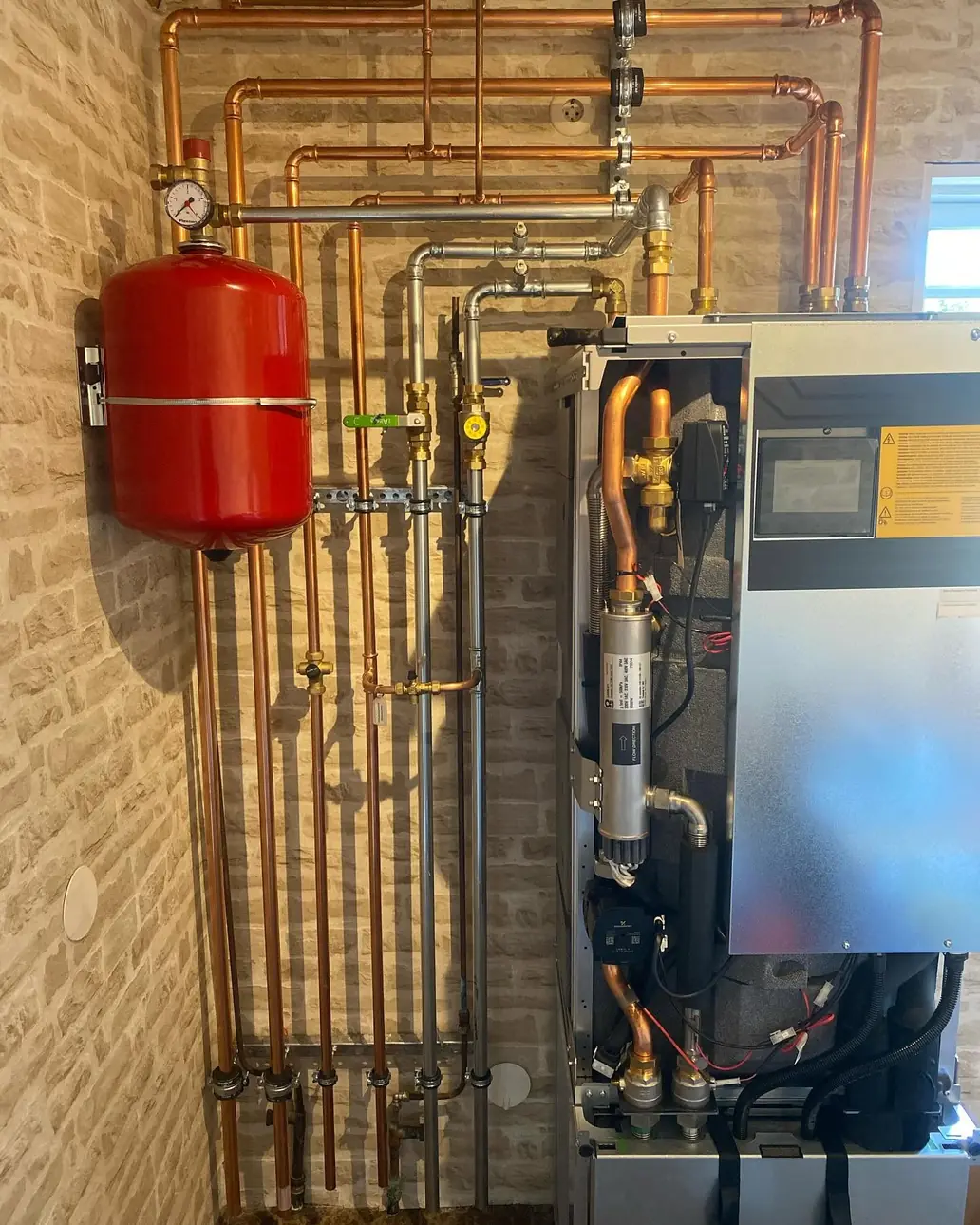 Värmepump med öppen front, expansionskärl och kopparrör, installerad av Växjö VVS